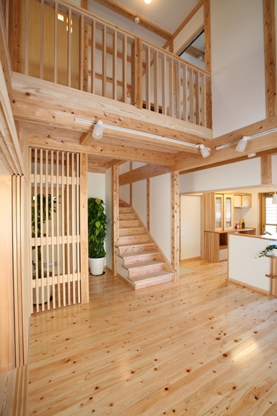 大きな吹抜けで開放感のあるリビング。
柱が見える真壁づくりに薩摩中霧島壁の塗り壁、床はヒノキの無垢板と、自然素材で心地よく過ごせる。