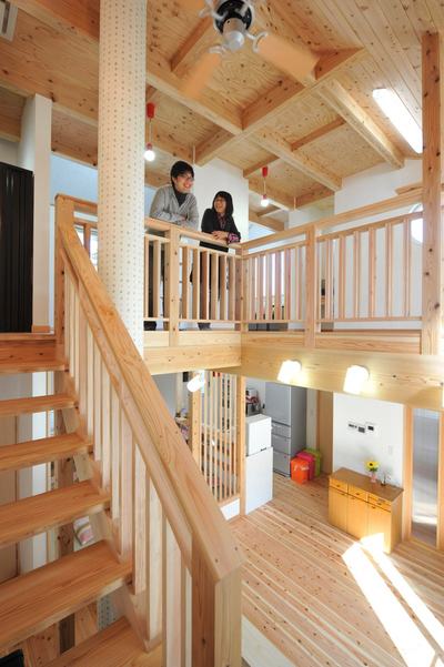 LDKは2階へと続く階段も含め、高い吹抜けが開放的です。一見、大きな柱かと思いきや実はOMソーラーのダクトです。かわいい木の模様のクロスを張り、空間に馴染んでいます。 LDKは2階へと続く階段も含め、高い吹抜けが開放的です。一見、大きな柱かと思いきや実はOMソーラーのダクトです。かわいい木の模様のクロスを張り、空間に馴染んでいます。