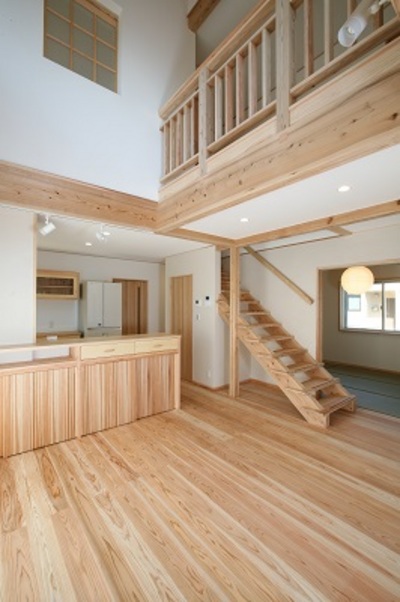 吹抜けが開放的な明るいリビングダイニング。階段下のデッドスペースは収納を設け有効活用。