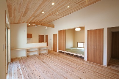 美しい杉板が貼られた勾配天井と広いお庭とウッドデッキへ繋がる開放的なリビング。リビングの壁はほたて漆喰を使用し、いつでも空気は爽やか。