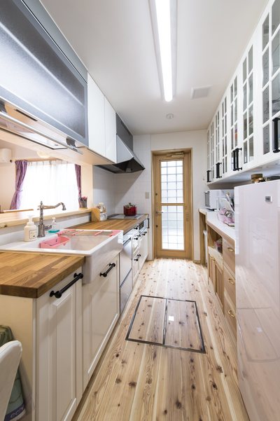 白を基調とした扉カラーのキッチンと吊戸棚。取っ手は南欧風にアイアン素材に。