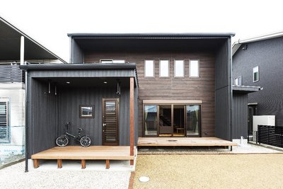 チャコールグレーと木調のサイディングを張り分けた重厚感のある外観。
