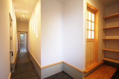 木製の造作ドアを開けるとＬＤＫへと繋がり、土間の方にあるドアは防音室入口になります。