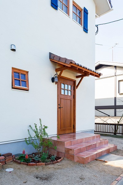 玄関に続くアプローチは、2人で出かけたガーデニングが華を添える。季節の花たちが訪れたゲストを優しくお出迎え。