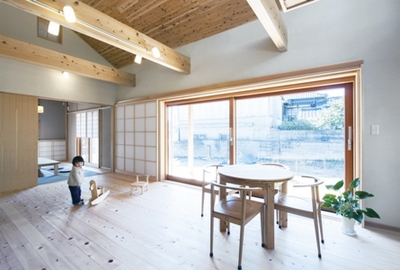 1枚が約2ｍ角のワイドな木製サッシはとても開放的。2枚のサッシを引き込むとウッドデッキはリビングとひと続きになります。