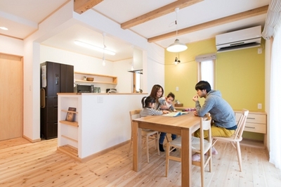 ダイニングスペースの壁の一面だけにライムグリーンのアクセントクロスを取り入れ、天井は構造材の梁だけ見えるようにして木の分量を控えめに。