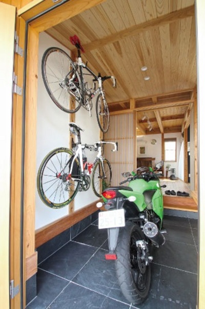 「ここでパーツを組み立てたり、メンテナンスをしたりしています。」町屋を思わせる玄関土間とつながるガレージ、その先に広がるリビングからも自慢のバイクを眺めることができる。