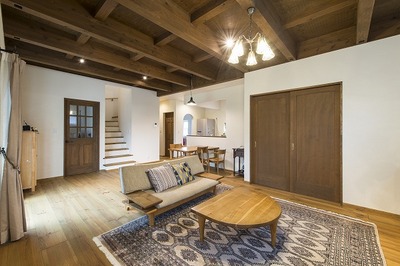 高い天井を希望されたので梁出しスタイルにしました。
ダイニングリビングは家具を最小限にとどめてスッキリした雰囲気に。キッチンは正面右にあり2階からの生活導線距離を考慮してつくりました。玄関ホール、洗面、家事室、キッチンという導線も考慮しています。