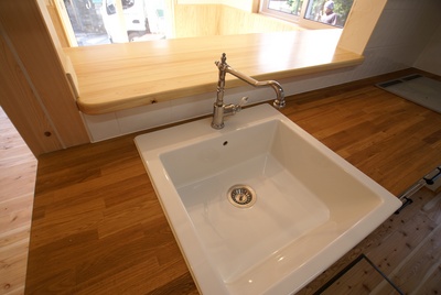 キッチン天板は木の天板にシンクはおしゃれな水栓の陶器のシンク。