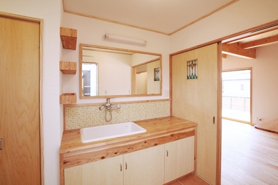 洗面脱衣室。キッチンのすぐそばで、便利な家事動線となっている。
造作の洗面台と鏡は大きく、子どもたちの朝の身支度もスムーズに。