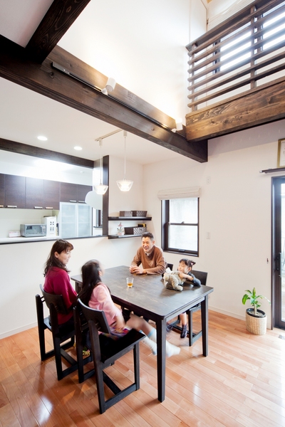 吹抜けから明るい光が注ぐダイニング。
大工さん手づくりのテーブルは家族みんなで茶色に塗装し、一体感のある雰囲気に。