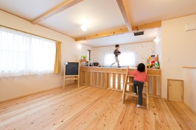 ステージのようなフリースペースは子供たちのお気に入り。木製の窓を開け閉めして空調を調節できるよう無双窓を取り入れ、1階からも家族の気配が感じられます。