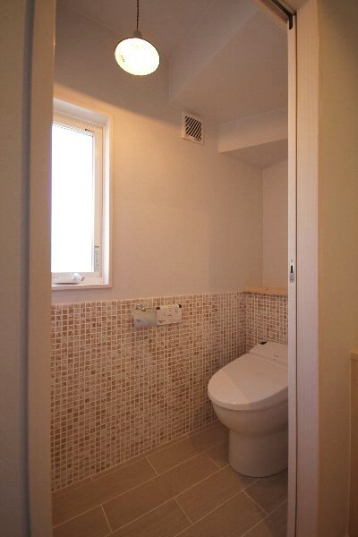 壁も床もタイル貼りで清潔感アップ。暖色系のタイルにしたことであたたかさもある空間に。