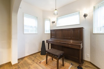 リビング南側にコンサバトリーのようなスペースをつくり、道路からの視線を考慮して窓は緑が見える程度の高窓にしてピアノを配置しました。