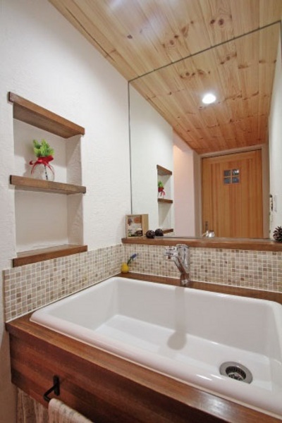 奥様のお気に入りの場所。大きな洗面台にタイル張りされた壁や棚など手作り感ある雰囲気が女性らしい空間。