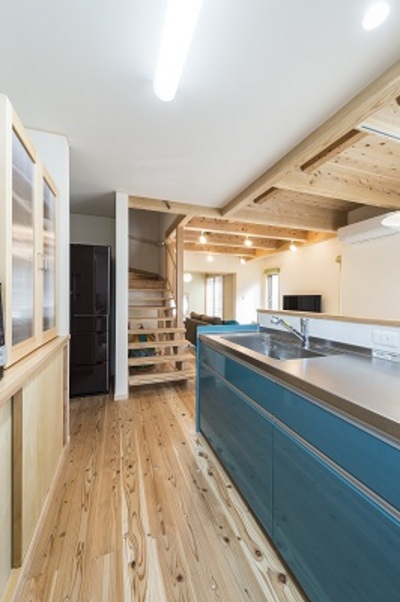 奥様お気に入りのターコイズブルーのキッチン。生活感を見せないように冷蔵庫は仕切りをつくって収めています。 奥様お気に入りのターコイズブルーのキッチン。生活感を見せないように冷蔵庫は仕切りをつくって収めています。