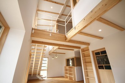 二か所の吹抜けから陽が差し込む明るいリビング