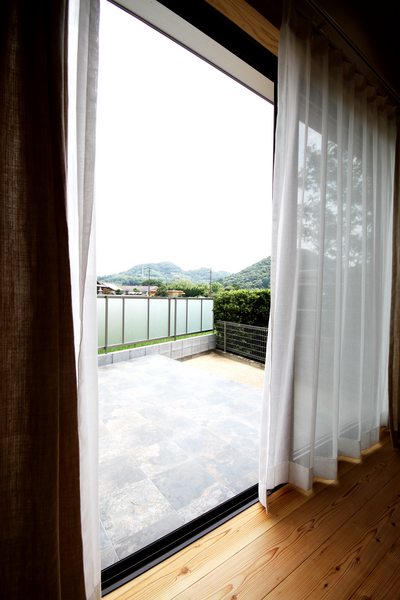 窓の先の空や緑の山々をみて癒されるリビング