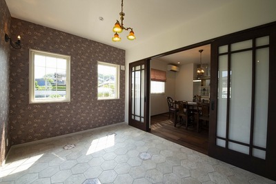 愛犬の為に設けたコンサバトリーですが、奥様が一番お気に入りの場所でした。床に掃除しやすい六角 タイルに、アンテーク風のタイル6種類を取り入れてアクセントにしました。花柄の壁紙を 全面に張り、雑貨屋さんで見つけたアンティック照明を。引越が一段落したらここでゆっくりお茶するのを すごく楽しみにしていますと奥様が嬉しそうに話されました。