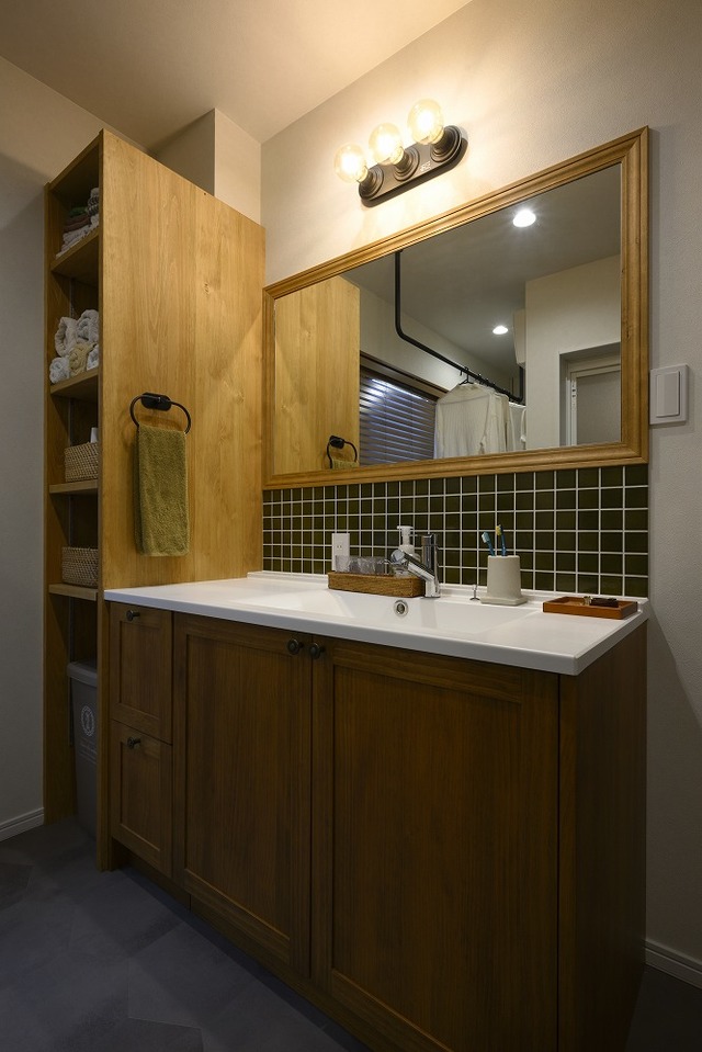 洗面脱衣所にはランドリースペースも設けました。
化粧台は無垢を使用。横には可動棚を設け収納するものによって高さを自由に変えられます。