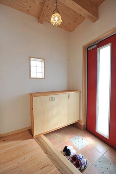 鮮やかな赤が印象的な玄関。タイルにはビー玉を敷き詰め、オリジナルでとてもかわいいです。