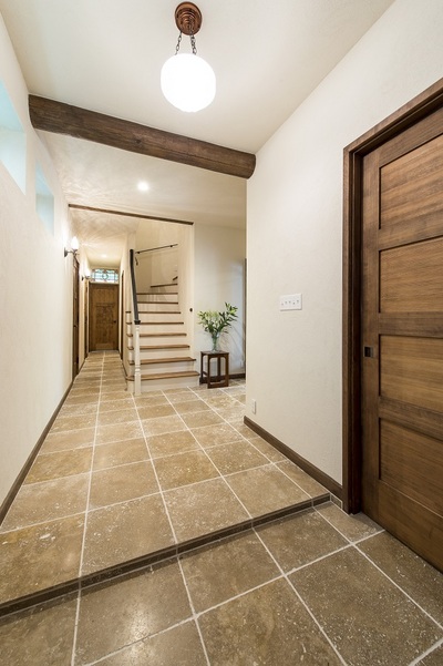 広い玄関ホールには、廊下まで続く天然の大理石をあしらい、さらに広々と見せています。
虫食いの穴が開いた天然石は、人口石とは違う雰囲気があります。