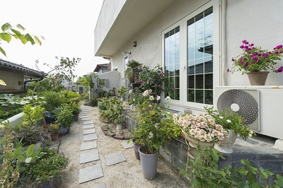 庭のグリーンは以前から奥様が手塩にかけて育てていたものです。あまり広い庭でもないけど植栽の配置は計画されていて素敵な空間になっています。庭に続く小道もタイルを並べるだけでこのように素敵な空間になっています。