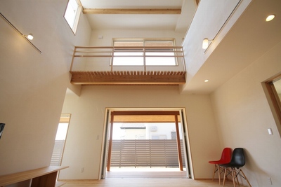 上部の大きな窓からたくさんの光が降り注ぐ、明るいリビング。