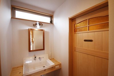 洗面コーナー。オリジナルの造作建具のガラスは光を通すとゴールドに感じられます。