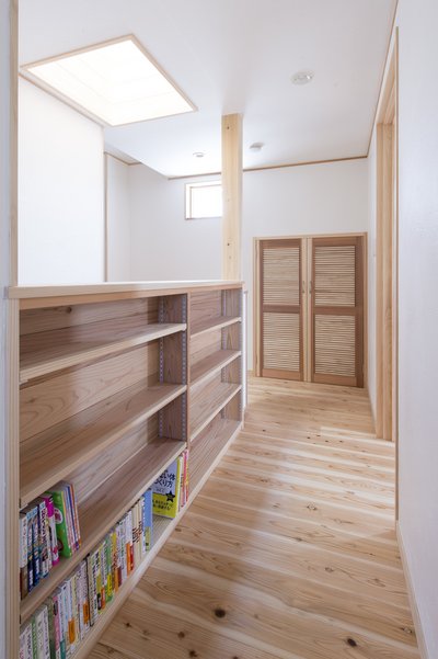 書棚を備えた2階ホール。天窓からの自然光が階段を通じて1階まで届く。