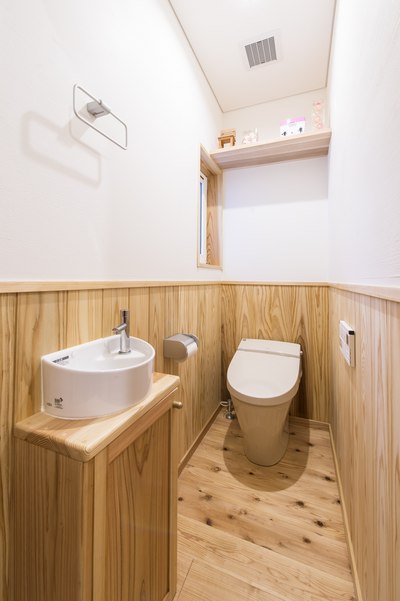 腰壁に無垢材、壁に漆喰を施したおしゃれなトイレ。トイレも人気のタンクレスに。