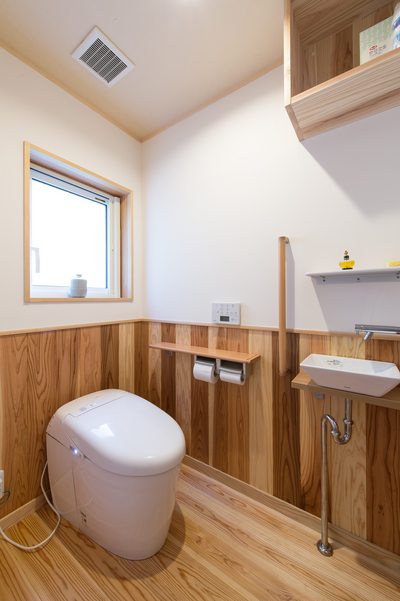 無垢材の腰壁と丸みのある便器でかわいらしいトイレに。