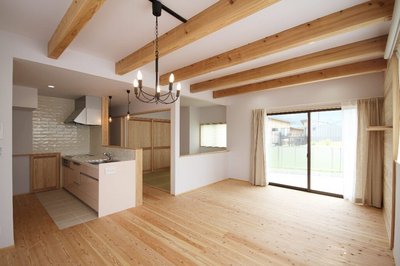 ひと続きに仕上げたLDK＋和室。ひと続きながらも、和室は腰壁で仕切り、ちょっとこもり感もある落ち着く空間に。キッチン奥は階段下を利用したパントリー。