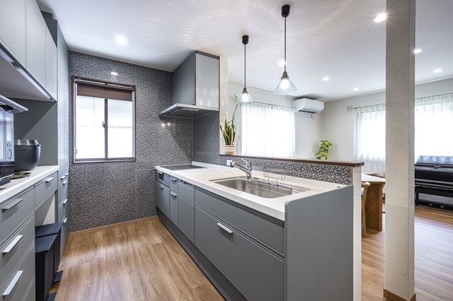 タイル調のキッチンパネルを3方に貼り、お手入れしやすく、また高級感も感じられます。
落ち着いたトーンのキッチン、ペンダントライトはお気に入りです。