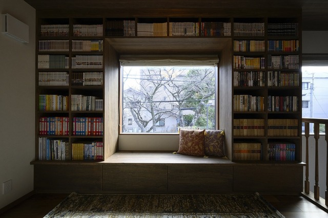 2階のホールには、造作の本棚とヌックを設けました。
真ん中のFIX窓からは、目の前にある公園の木々を眺められ、四季折々の風景を楽しむことができます。
本棚は、お持ちの本の大きさに合わせ造作しました。足元は引き出し式の収納にしています。