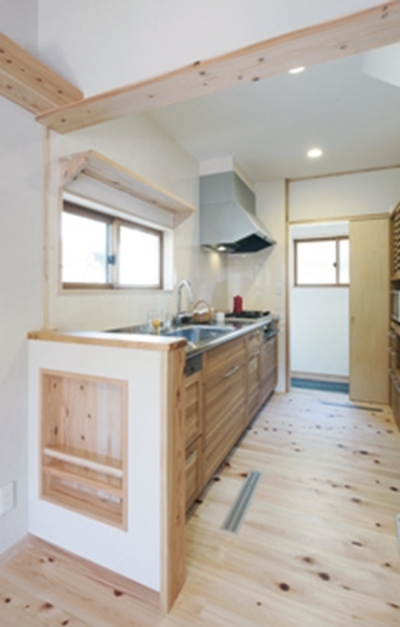 キッチンから土間へ便利な生活動線。無垢風のキッチンパネルは床に合わせてコーディネートしました。