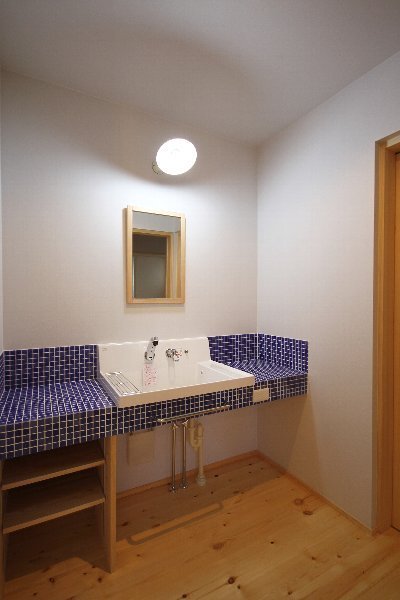 ナチュラルな室内に映えるブルーのタイル貼り洗面台