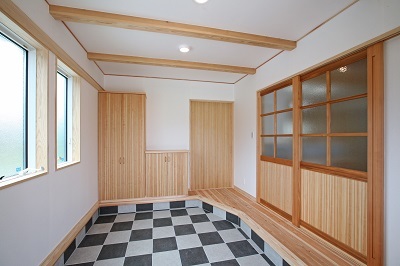 玄関から入る建具は無垢材でつくったオリジナルデザイン。市松模様のタイルがお出迎え。 玄関から入る建具は無垢材でつくったオリジナルデザイン。市松模様のタイルがお出迎え。