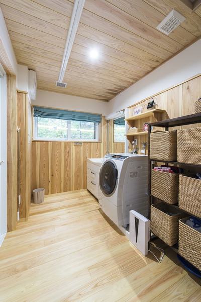 広々とした洗面脱衣所。高めの腰壁と木の天井で漆喰の壁がアクセントに。