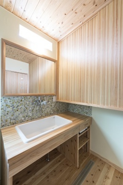 洗面室には収納力抜群の造作収納。落ち着いた雰囲気のタイルがアクセント。