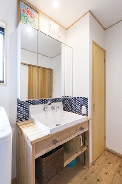 洗面台のタイルはブルーをチョイス。浴室の壁とリンクさせ統一感を出しています。