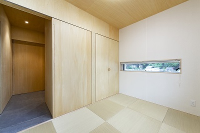 4.5畳ほどの和室は琉球畳と和紙クロス、天井に貼った木の板に囲まれた癒しの空間。あえて小さく取った窓がアクセントに。