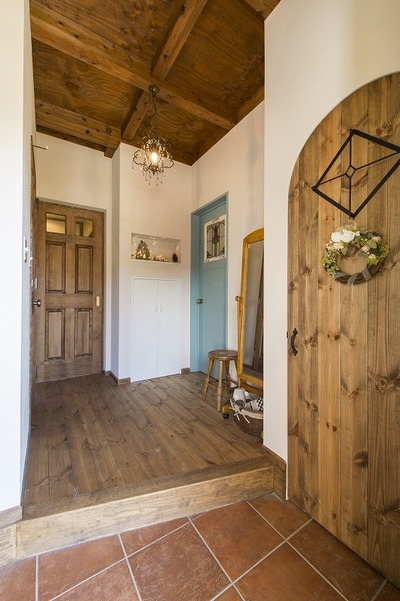 　お父様から新築祝いで造って頂いた陶器の照明を設置するため、玄関にニッチを設>けました。
建具の多くは弊社のオリジナル仕様。2階は１階と雰囲気を変えて明るめにコーデイネートしています。通路には書棚をもうけています。