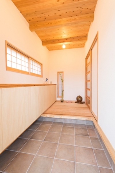 土間のある落ち着いた雰囲気の玄関には、奥行きを生かした収納棚を設置しました。採光も充分明るく、訪れた人が気持ちの良い空間です。