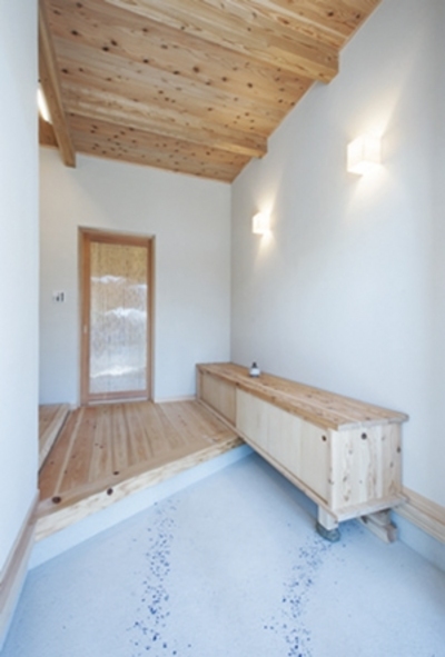 銀河のような色ガラスが印象的な玄関。壁のブラケット照明は和風テイストでまとめました。