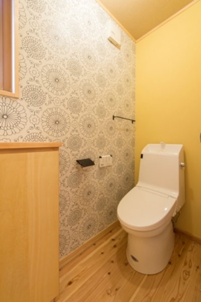 トイレはリビングからワンクッション距離を置き、洗面台スペースの先に設けました。大輪の菊柄の個性的なクロスが印象的。 トイレはリビングからワンクッション距離を置き、洗面台スペースの先に設けました。大輪の菊柄の個性的なクロスが印象的。