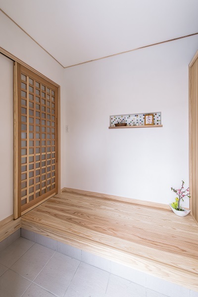 玄関から入るドアは無垢材でつくったオリジナルデザイン。ニッチに施した可愛いカラフルなタイルがお出迎え。 玄関から入るドアは無垢材でつくったオリジナルデザイン。ニッチに施した可愛いカラフルなタイルがお出迎え。