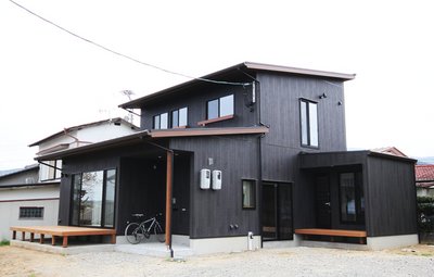 黒い外壁に木調が彩りを添える外観