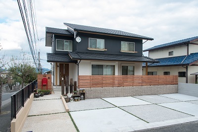 白と黒のツートーンでデザインされた外観。駐車スペースはゆとりをもたせ、赤い郵便受けがアクセント。ガーデニングが楽しめそう。