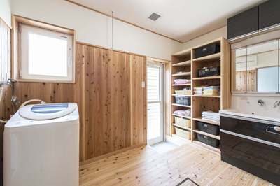 黒い光沢のある扉色がかっこいい洗面台のある洗面脱衣所。